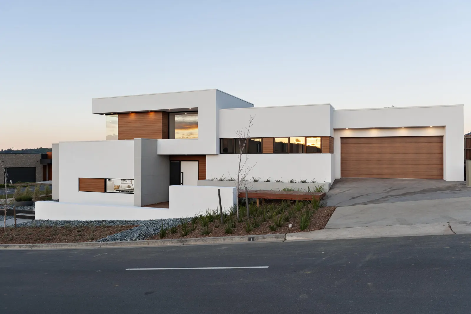 Front exterior at twilight with timber garage door and layered facade, Canberra