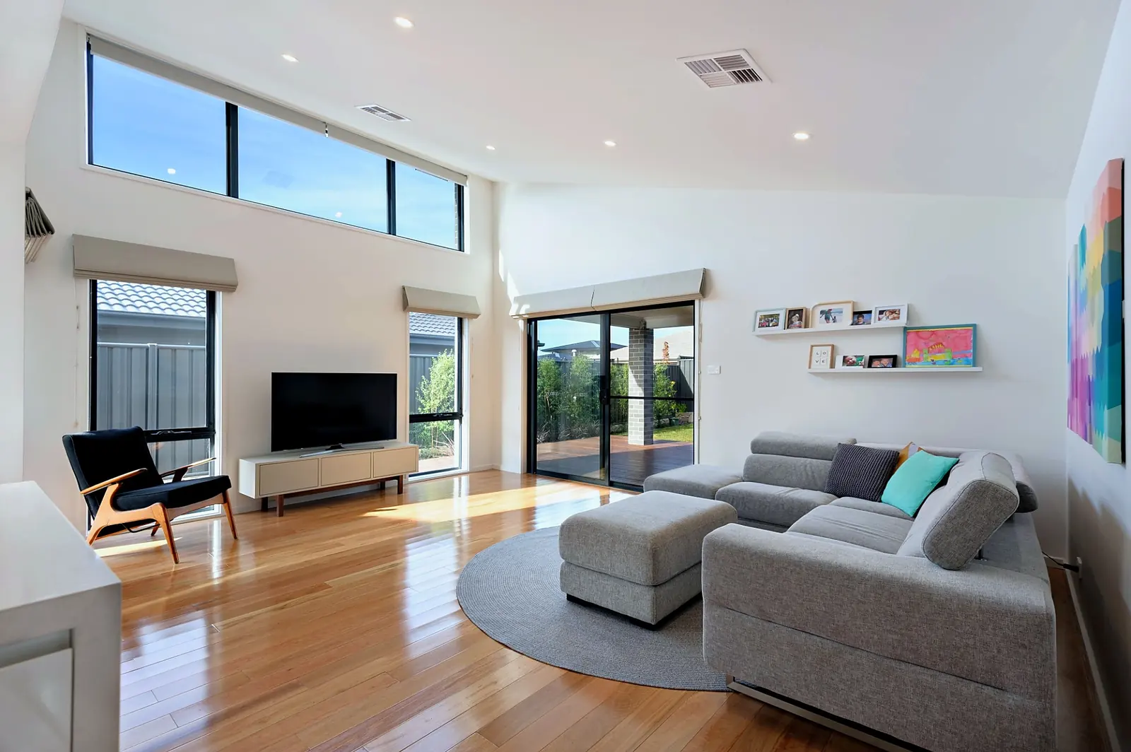 Living room with raked ceiling, highlight windows and timber floors