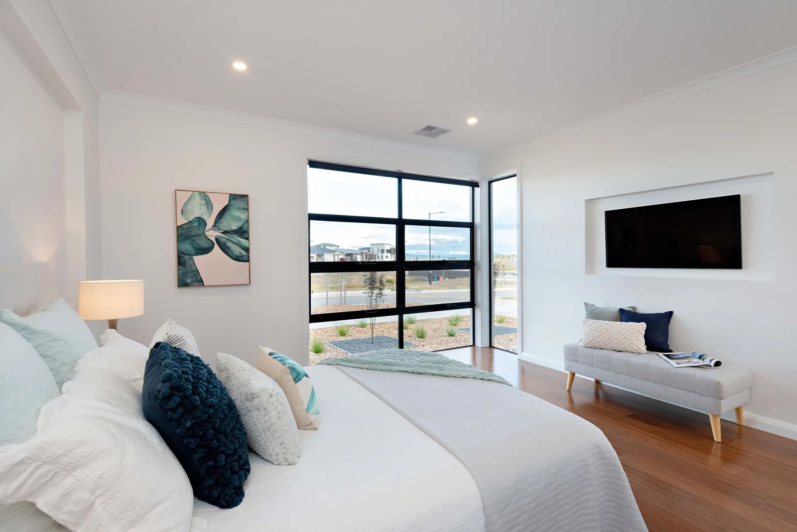 Master bedroom with black framed corner window and recessed television nook