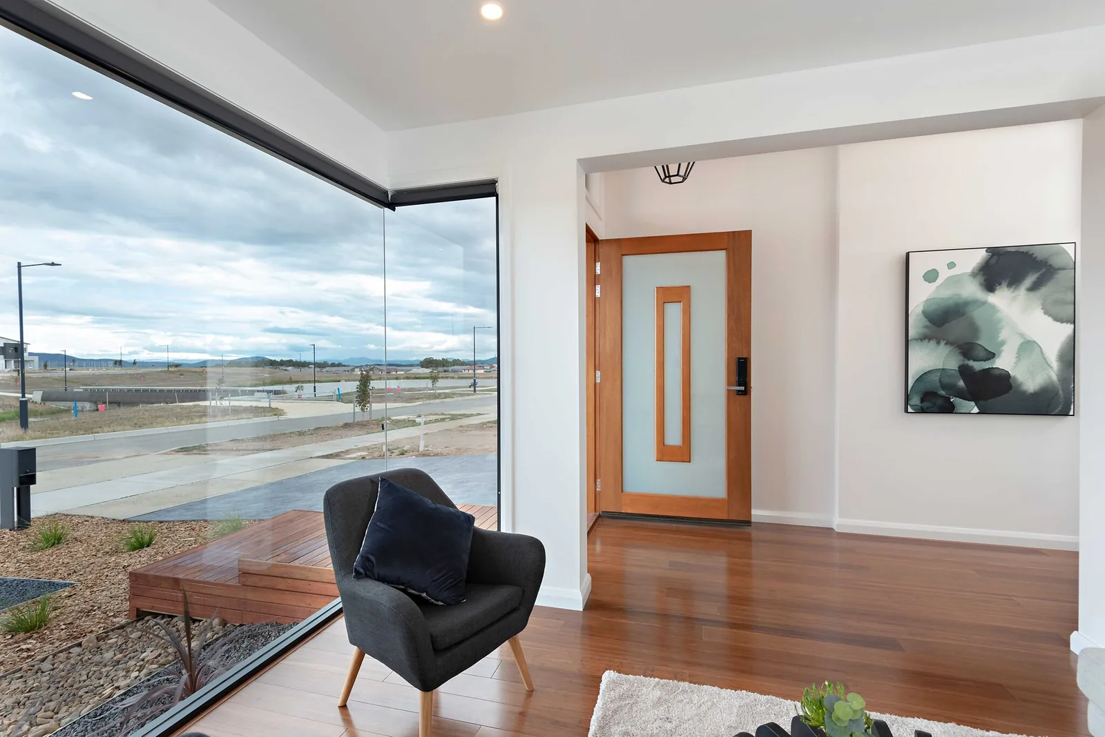 Entry with timber front door and full height corner glazing to the street