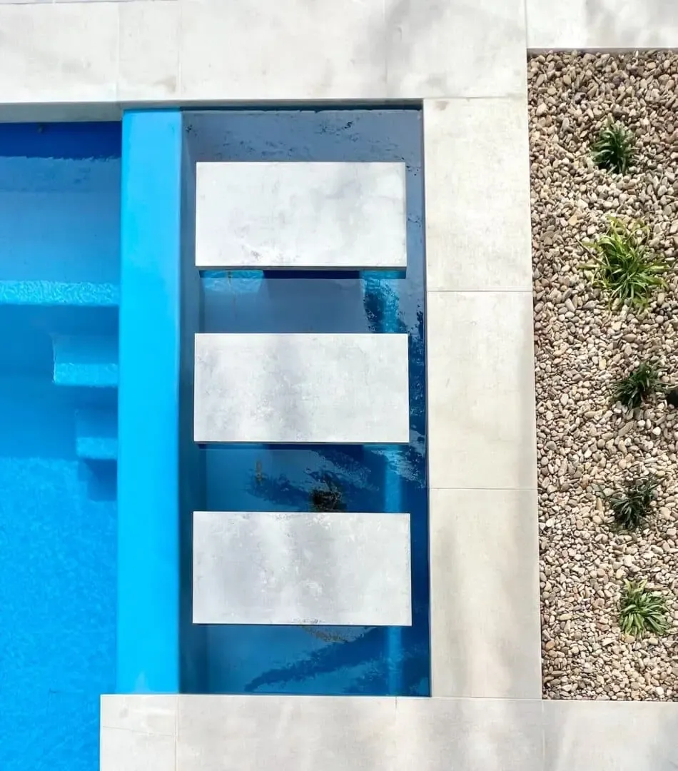 Swimming pool with floating concrete stepping pads