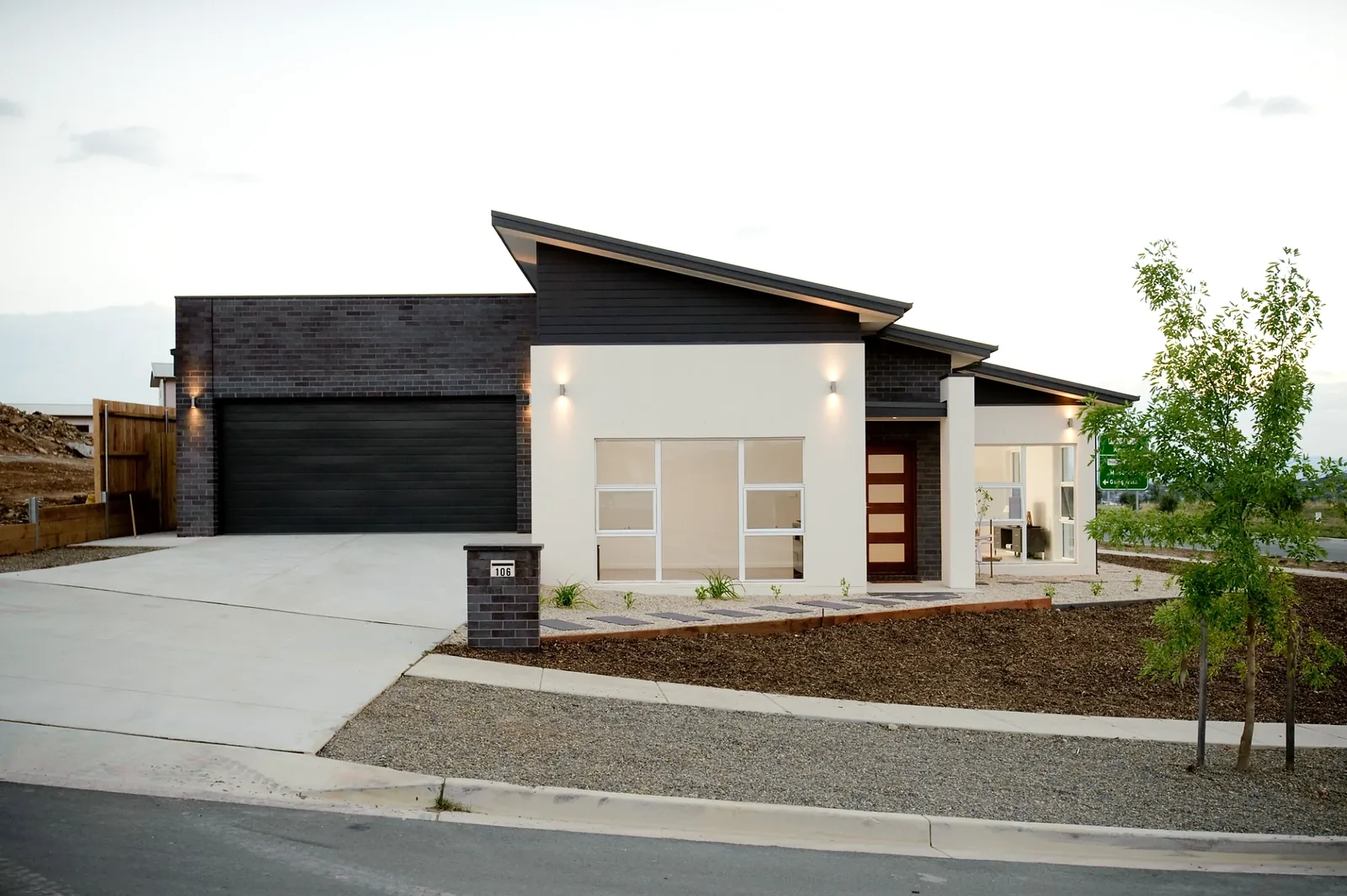 Completed new home with skillion roof and feature brickwork at dusk, Bonner ACT